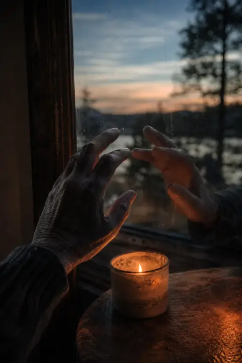 Translucent hands mirror each other across candlelight, trembling in sync, dead father dream symbol