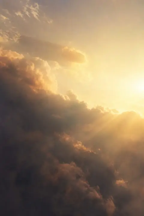 A mass of dark smoke disperses across a sunlit sky, thinning to faint golden haze, a dream of demons attacking
